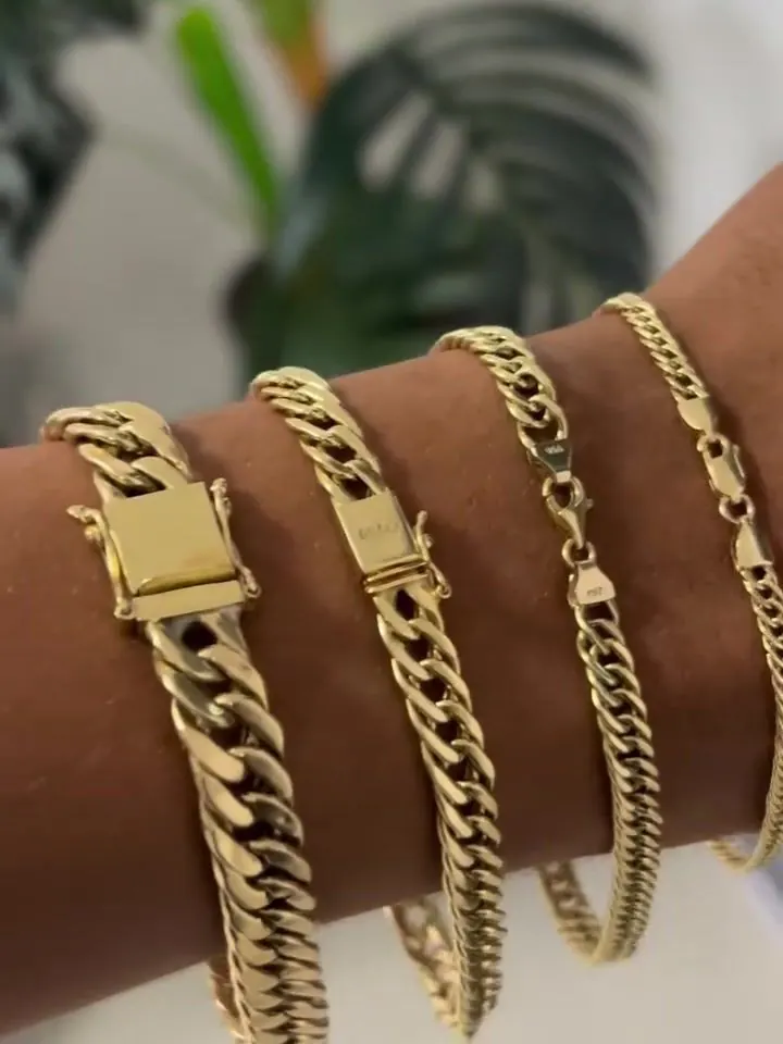 Três pulseiras grumet em ouro 18k no pulso, com os fechos alinhados