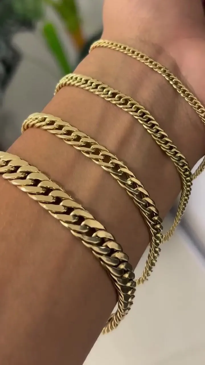 Cinco pulseiras grumet em ouro 18k empilhadas no pulso, em close