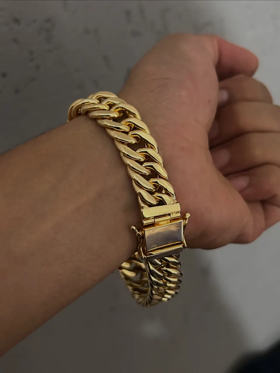 Pulseira grumet dupla de 15 mm em ouro 18k no pulso, com fecho articulado em destaque